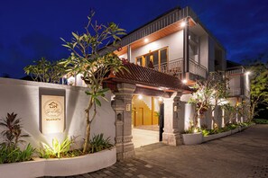Un bâtiment moderne à deux étages, doté d’une entrée bien éclairée, d’une enseigne et d’un espace paysager aménagé en jardin.