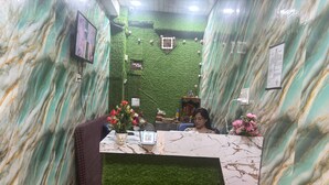 A reception area with a marble counter, green artificial grass, and a brown leather chair. - Hotel Youvraj Inn (Ghaziabad)