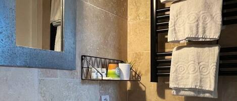 A bathroom with a sink, toilet, and towel rack.