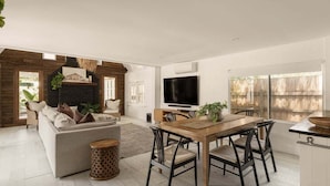 Uma sala de estar moderna com um sofá, mesa de jantar, cadeiras, televisão e lareira.