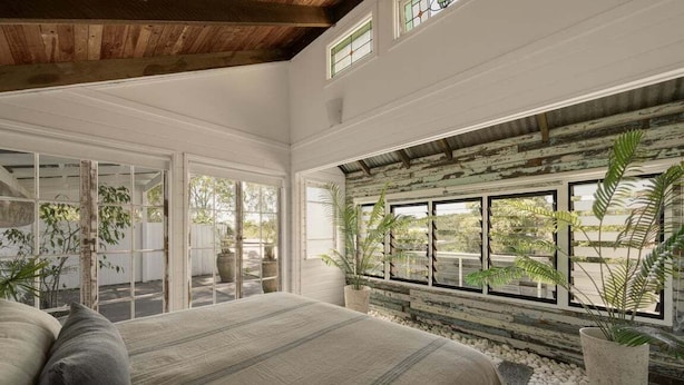 Quarto com uma cama grande, portas de correr de vidro e vista para o exterior.