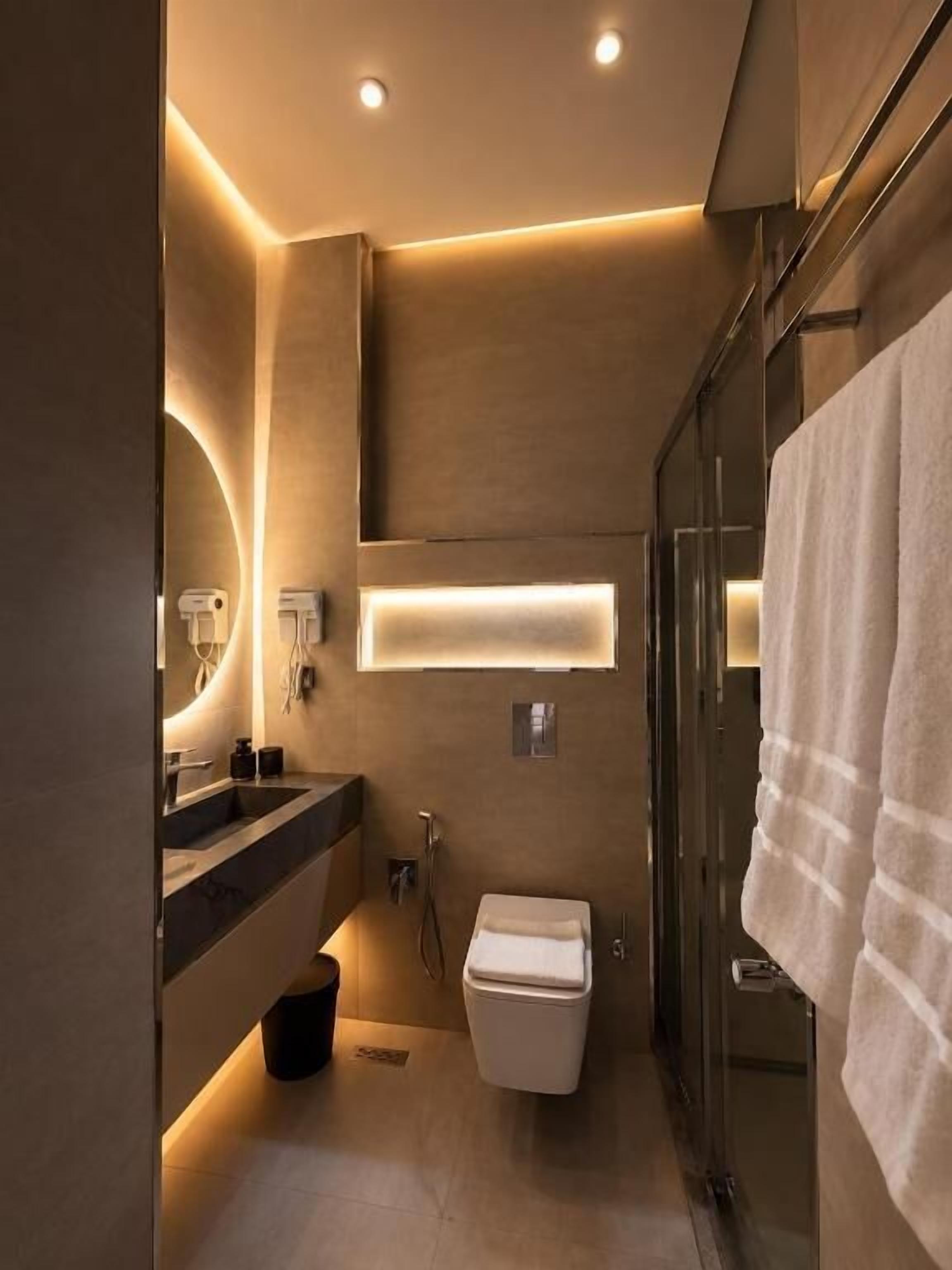 A modern bathroom with a glass shower enclosure, a toilet, and a vanity with a mirror.