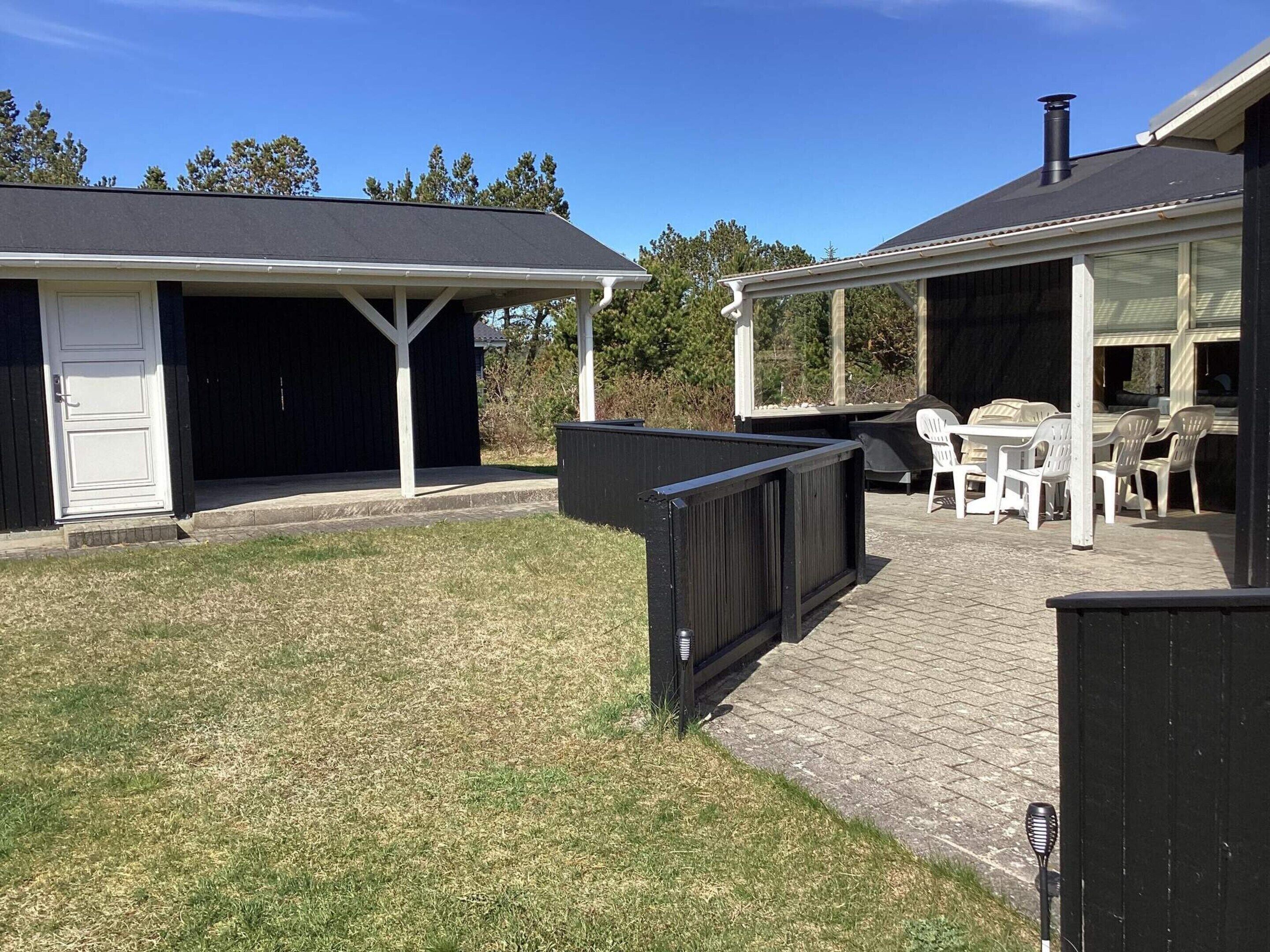 Un patio couvert avec des meubles d’extérieur et un barbecue.