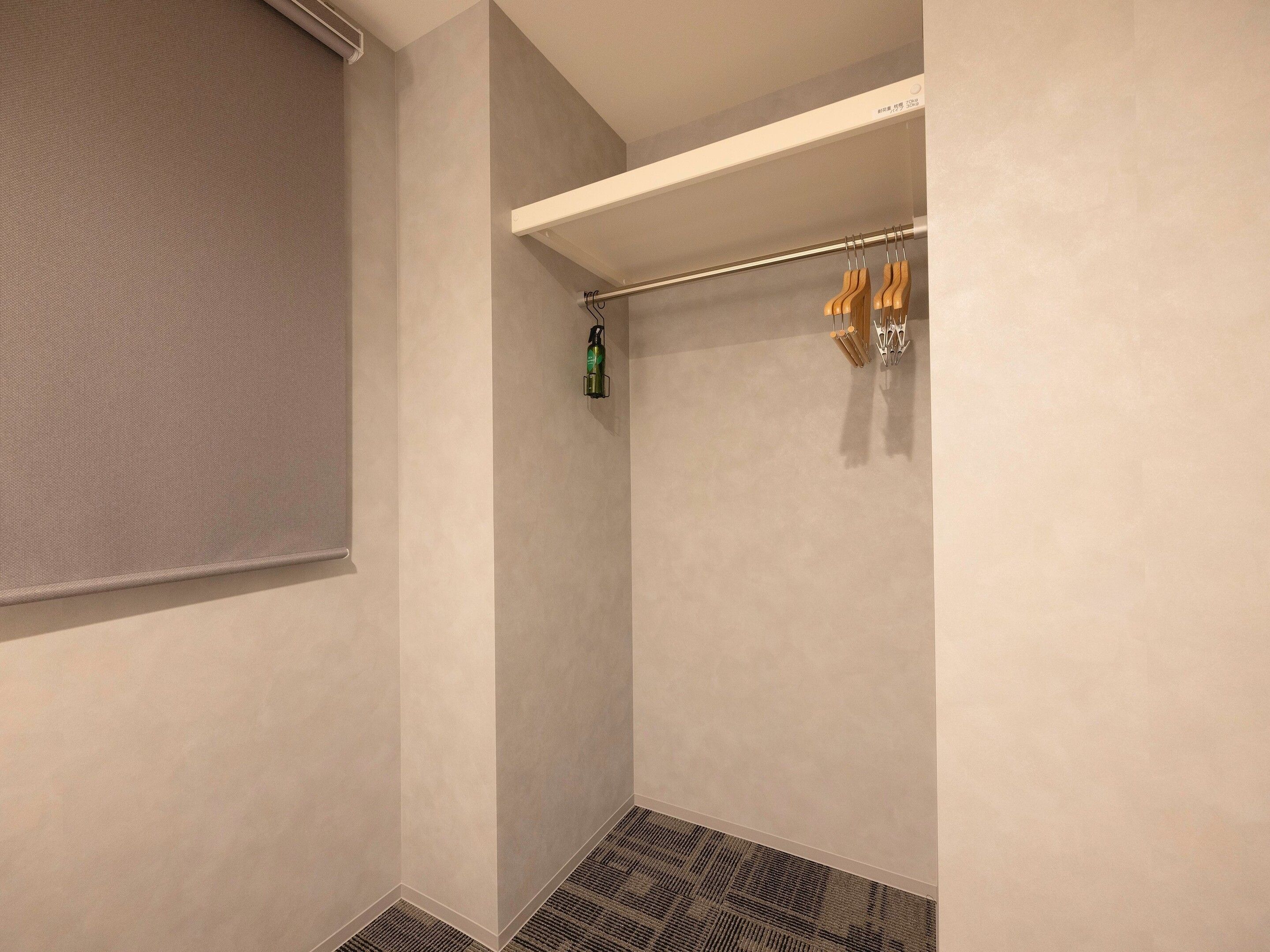 Un baño con ducha, un perchero y una botella verde, además de un piso con diseño.