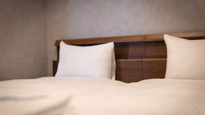 Una cama bien hecha con cabecera de madera y ropa de cama blanca.