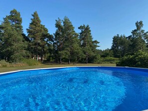 A clear blue swimming pool surrounded by trees. - 4 Star Holiday Home in Farjestaden (Farjestaden)
