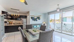 Eine moderne Küche mit Essbereich, ein Balkon mit Blick und einer hängenden Dekoration.
