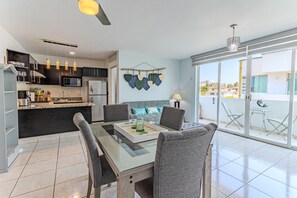 A modern kitchen with a dining area, a balcony with a view, and a hanging decoration. - Bright & Comfortable Condo in Heart of Versalles! 2BD Condo for rent in Versalle (Puerto Vallarta)