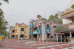 A row of colorful houses with a tiled walkway. - Varkala Escape Resorts (Varkala)