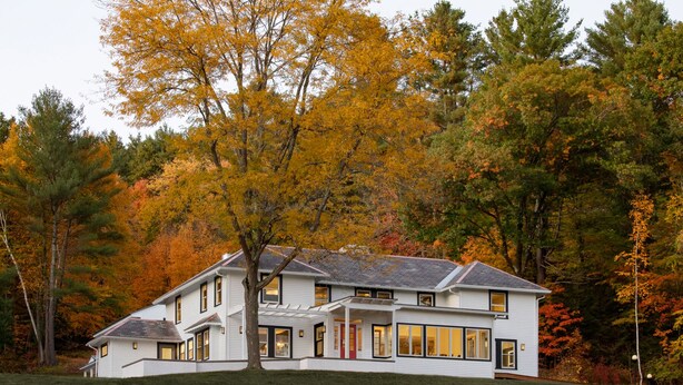 A two-story house with a large porch and multiple windows, surrounded by autumn foliage. - Shelburne Springs Hotel (Shelburne)