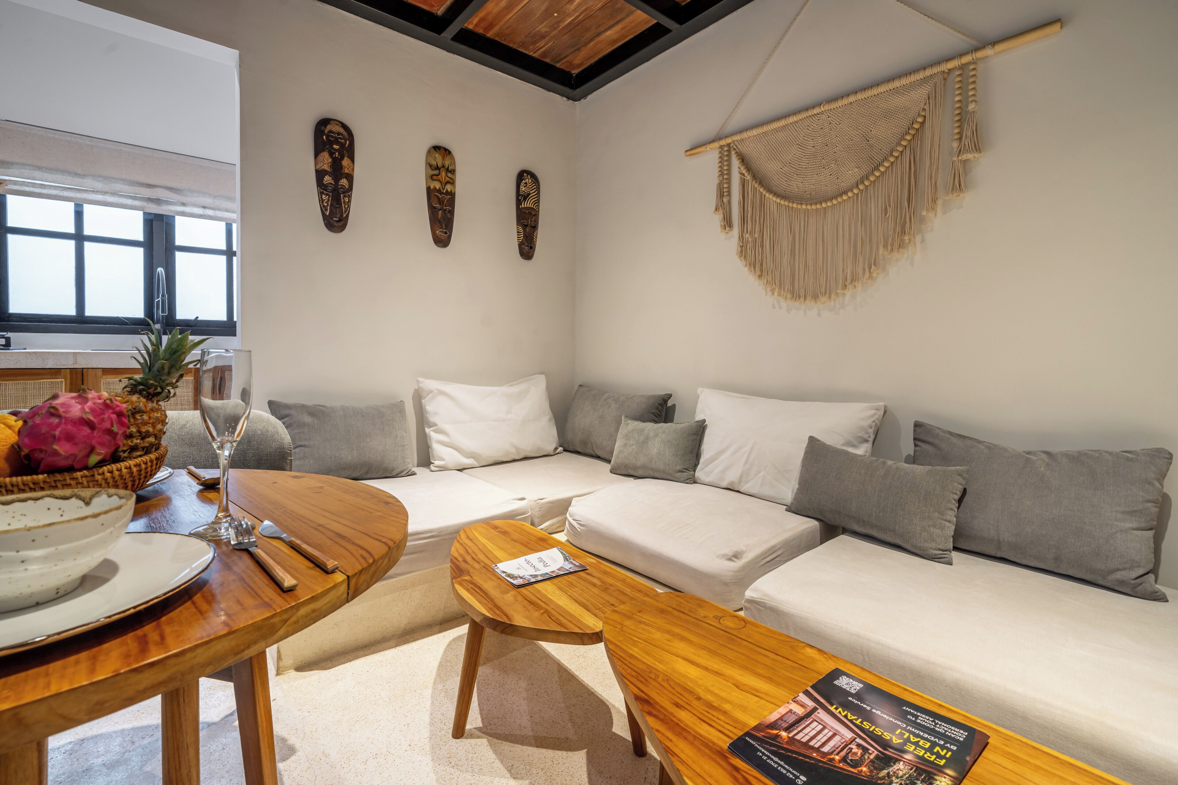 Una sala de estar moderna con un sofá, una mesa de centro de madera y decoración en la pared.