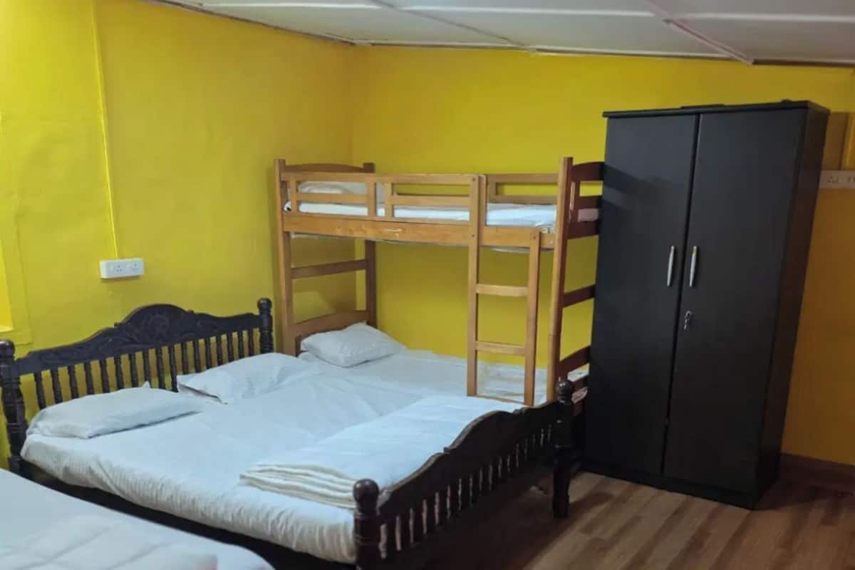 Una habitación con dos literas, un armario de madera y piso de madera.