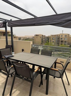 Outdoor dining - ALSAWAH Luxury suite w/Large Terrace & Electric pergola-palm parks comp. zayed (Giza Governorate)