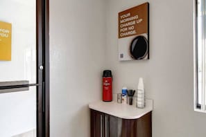Et hotelværelse med kaffemaskine, kopholder og et skilt der siger 'Opladning om morgenen uden beregning'.