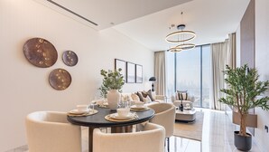 Una sala de estar moderna con comedor, ventanas amplias y vistas a la ciudad.
