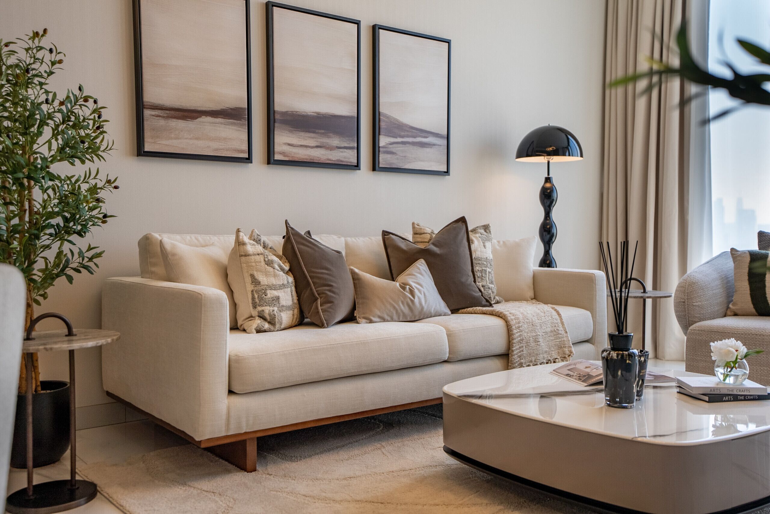 Een moderne woonkamer met een bank, salontafel en kunst aan de muur.