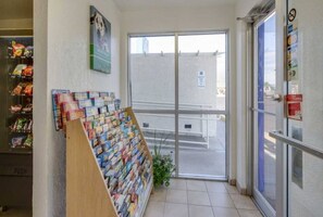 A bookstore with a display of books and magazines, a glass door entrance, and a poster on the wall. - 1 Queen Bed|NS| Micfridge (Lakewood)