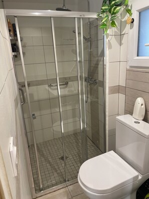 Chuveiro, secador de cabelo, toalhas de banho, papel higiênico