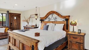 Une chambre à coucher avec un lit en bois, une table de chevet, une lampe et un élément décoratif mural.