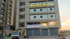 A multi-story hotel with a sign for 'Hotel Royal Sky AC Room' and a storefront for 'House of Lights & Home Decor.' - Hotel Royal Sky (Gandhinagar)