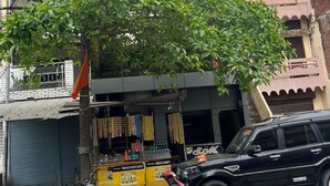 A hotel named 'Hotel Ram Raja Inn' with a modern facade, a visible entrance, and a tree in front.