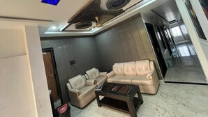 A modern living room with a sectional sofa, a coffee table, and a ceiling with a unique design.