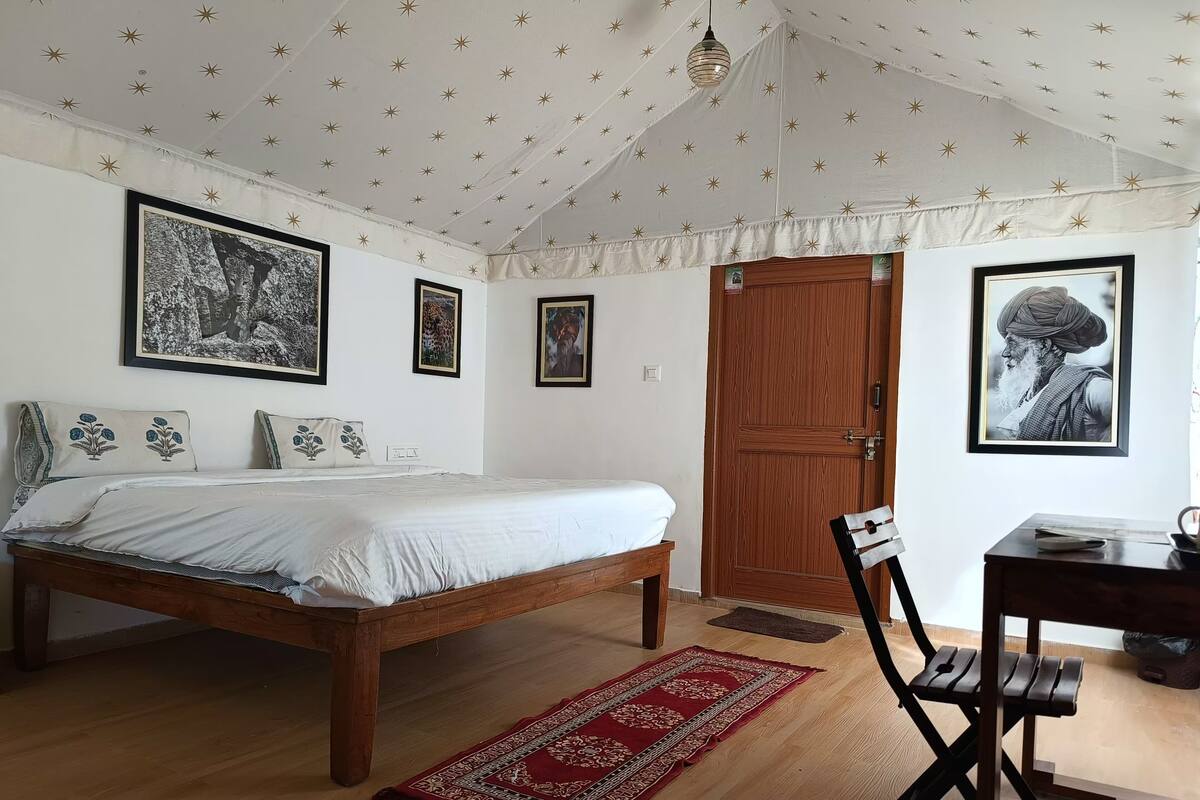 Un dormitorio con una cama, una puerta de madera, un escritorio y una silla.