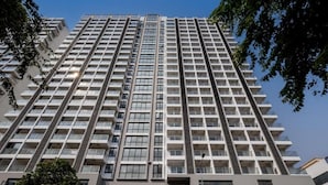 Un edificio de gran altura con varios pisos, balcones y un diseño arquitectónico moderno.