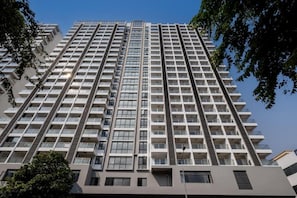Um edifício alto com vários andares, varandas e um design arquitetônico moderno.