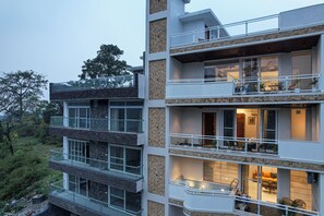 A multi-story building with balconies, large windows, and a stone facade. - Alaya Stays Udgam Vilas 3-BHK With Lift (Dehradun)