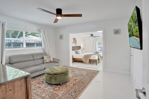 Una sala de estar moderna con un sofá, un reposapiés y una alfombra grande.