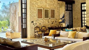 A stone-walled room with a sofa, chairs, and a coffee table.