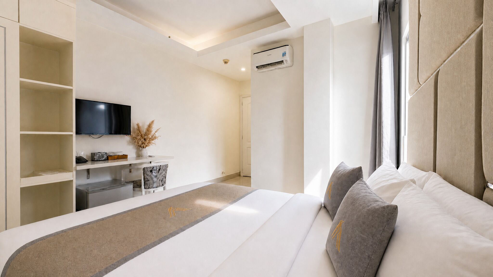 Een moderne hotelkamer met een groot bed, een televisie, een bureau met stoel en een kledingkast.