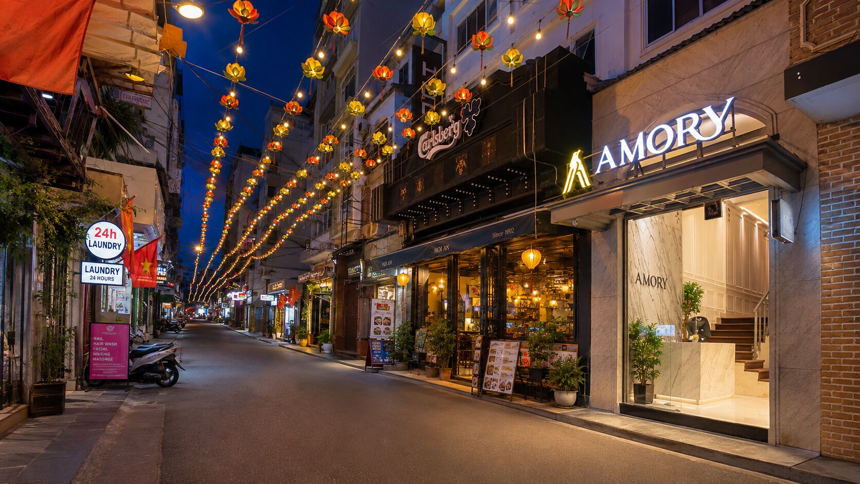 A street lined with shops, including a brightly lit restaurant named 'AMORY' with a marble facade.