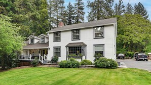 A two-story house with a porch, a garage, and a well-maintained lawn. - Close to Intel/Nike: Large Family Home w/ Hot Tub (Aloha)