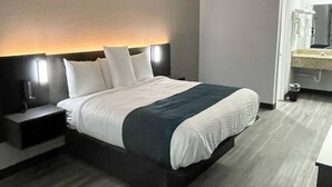 A modern hotel room with a bed, bedside table, and a nightstand. - 1 King Bed|Non-Smoking,Micfridge (West Columbia)
