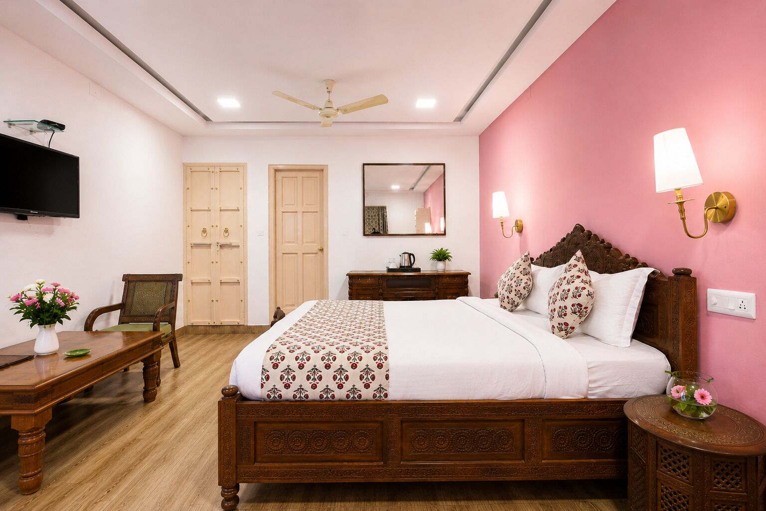 A bedroom with a bed, a desk, a chair, a television, and a ceiling fan.