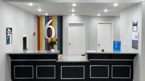 Zona de recepción con mostrador, letrero con el número 6 y una puerta.
