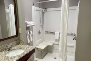 A bathroom with a granite countertop sink, a shower with a grab bar, and a mirror. - 2 Beds|Access|Tub|Nsmk|Micfridg (West Columbia)