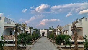 Un sendero conduce a un edificio de estilo arquitectónico tradicional, rodeado de vegetación.