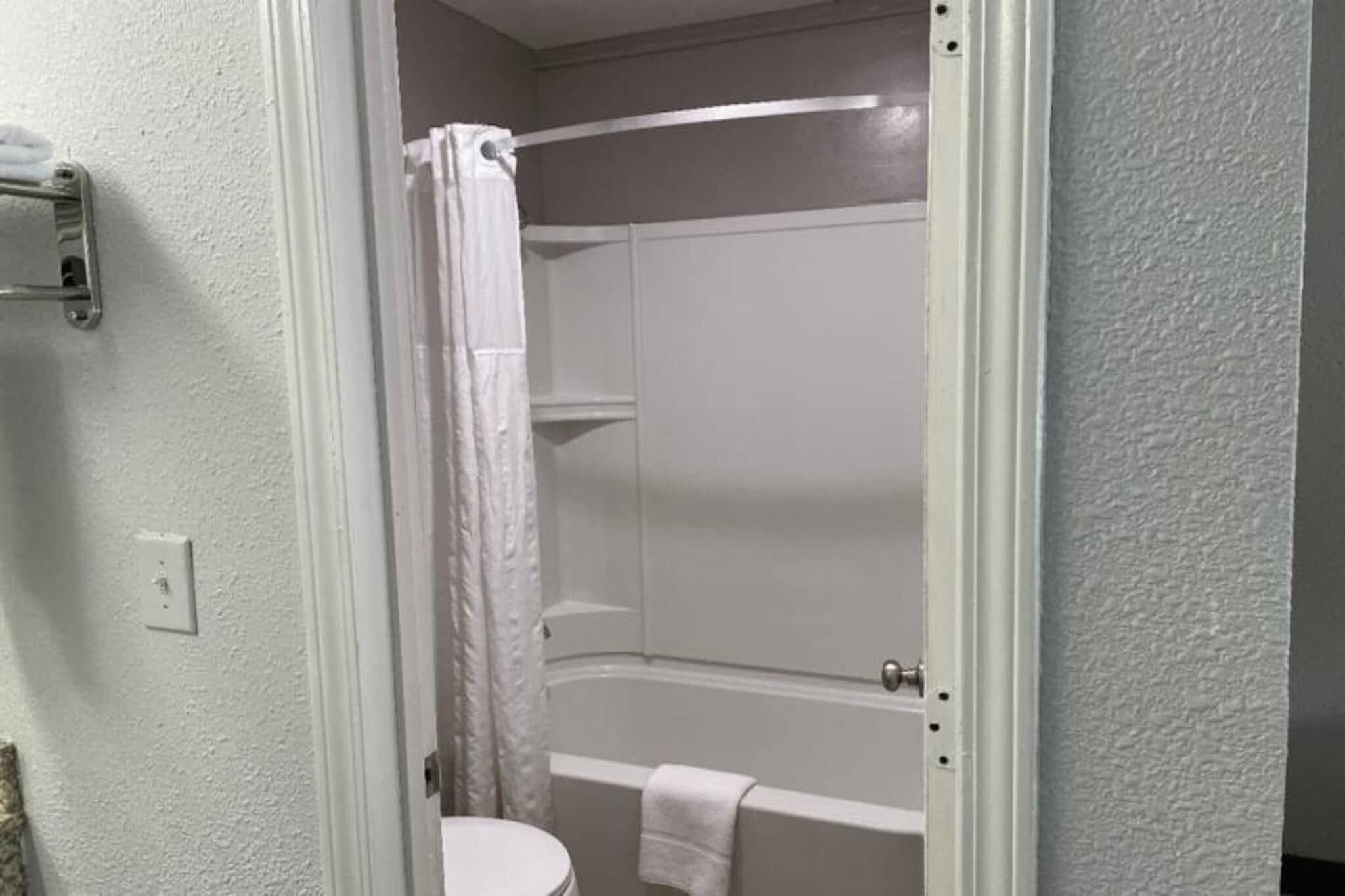 A bathroom with a bathtub, shower, and toilet.
