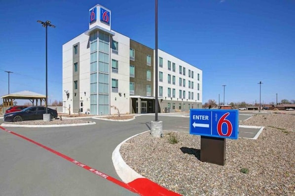 A 6-star hotel with a modern design, a clear entrance, and a parking area.