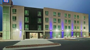 A modern hotel with a flat facade, multiple windows, and a parking lot. - 1 King Bed|Nsmk|Kitchen,Shower (Monahans)