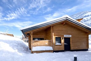 Eine Holzhütte mit einem Schild, auf dem 'SAUNA' steht, das auf eine Sauna hinweist.