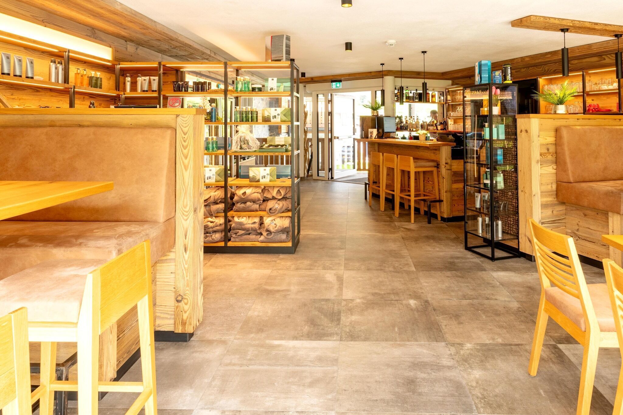 Un intérieur moderne avec des meubles en bois, un coin bar et des étagères où sont exposés divers objets.