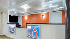 A reception area with a digital display, a number '6' sign, and a white door. - King Bed|Mob Acc|Nsmk|Microfridge (North Little Rock)
