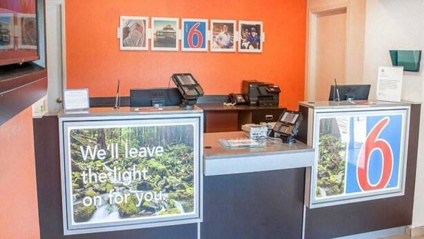A reception desk with a sign that reads 'We'll leave the light on for you.'