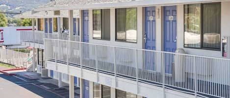 A motel with a two-story structure, numbered rooms, and a balcony.