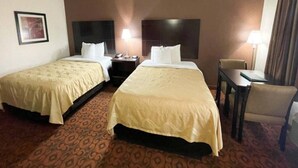 A hotel room with two beds, a desk, a chair, and a nightstand with a lamp. - 2 Queen Beds | Smoking, Micfridge (Oklahoma City OK)