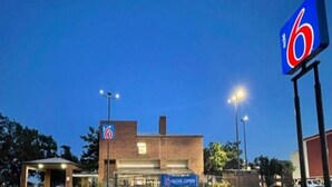 A 6 hotel's exterior at dusk with a 'NOW OPEN' sign. - 2 Queen Beds | Smoking, Micfridge (Oklahoma City OK)
